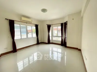 Spacious and bright corner unit living room with large windows and air conditioning.