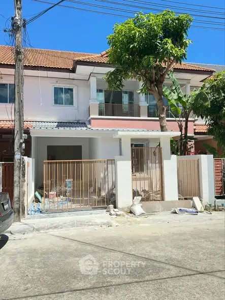 Charming townhouse with modern facade and gated entrance in a serene neighborhood.