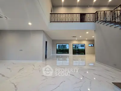Spacious modern living room with high ceilings and elegant marble flooring.