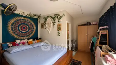 Cozy bedroom with vibrant tapestry and ample storage space, perfect for relaxation and comfort.