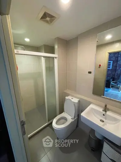 Modern bathroom with glass shower and sleek fixtures in a contemporary apartment.