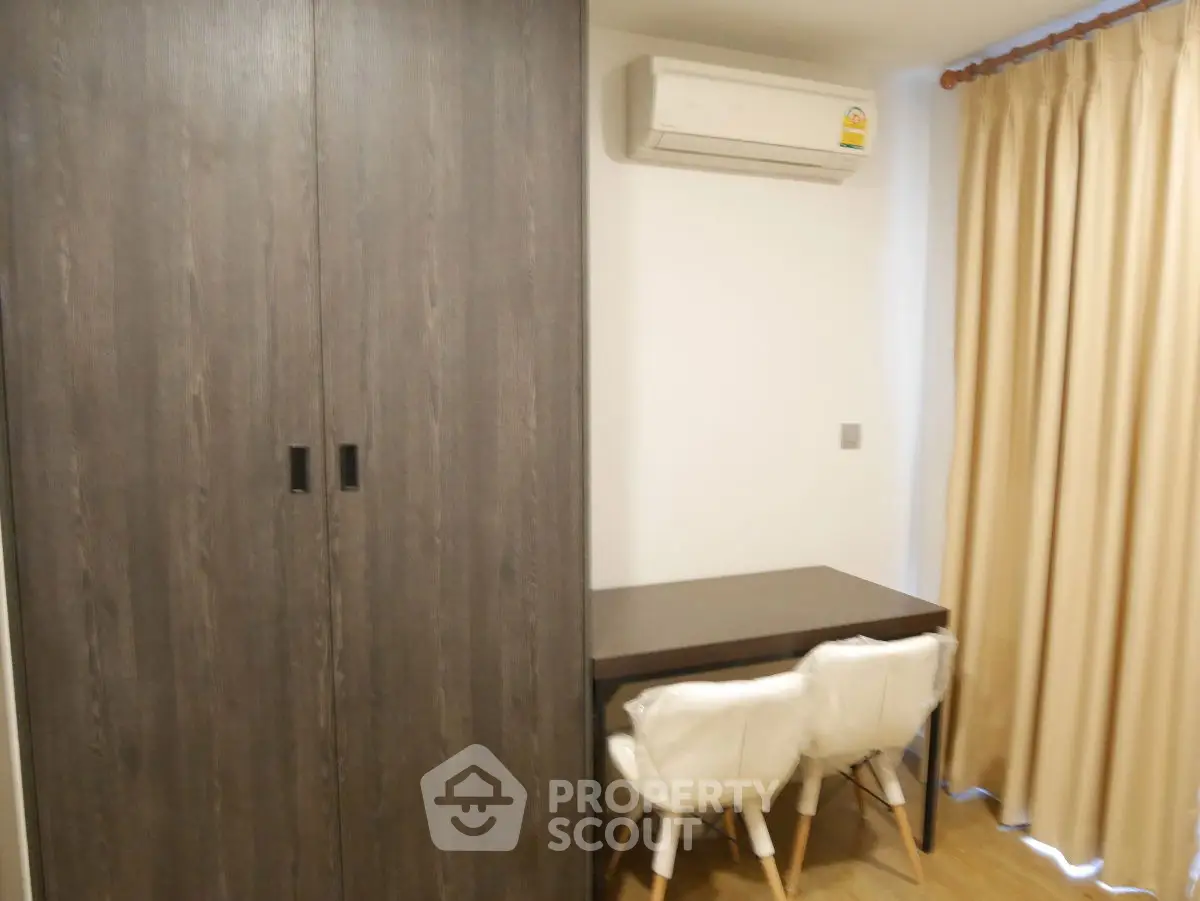 Cozy study nook with modern wardrobe and air conditioning in a stylish apartment.