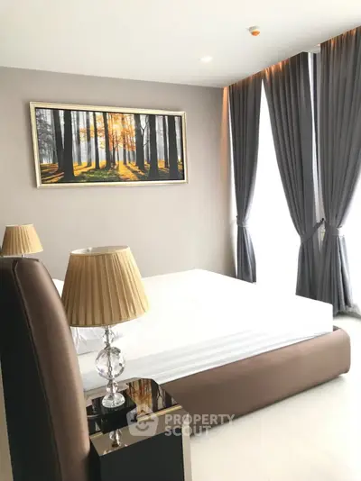 Modern bedroom with elegant decor and large windows offering natural light.