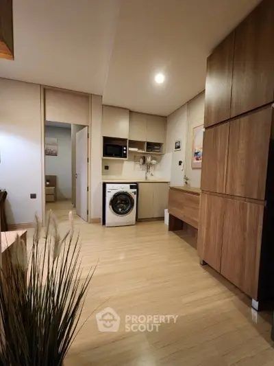 Modern compact kitchen with integrated washing machine and wooden cabinets