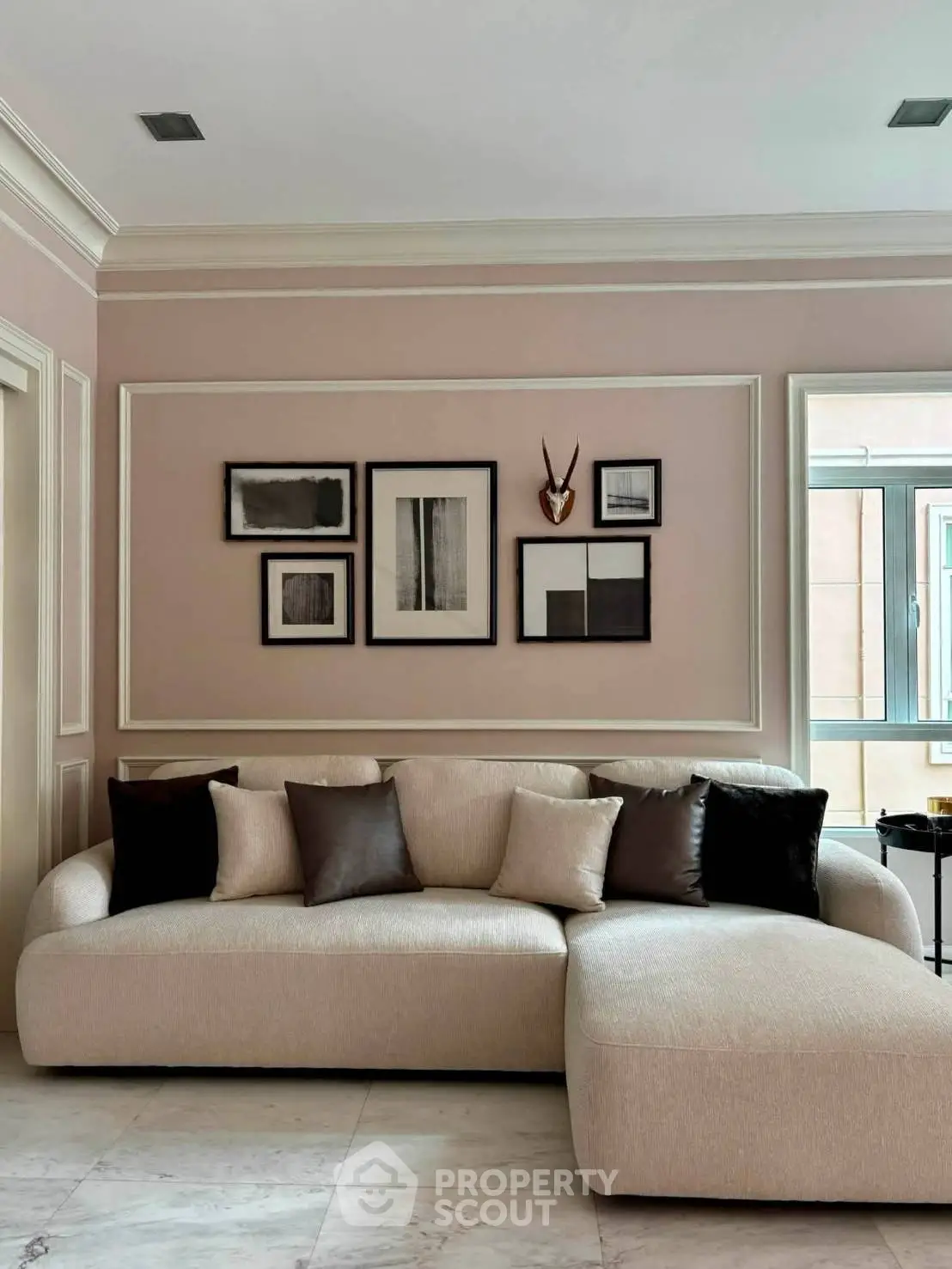 Elegant living room with modern decor and plush sectional sofa, featuring stylish wall art and natural light.