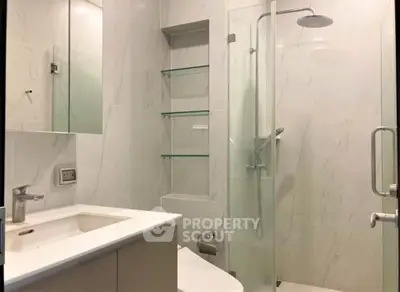 Modern bathroom with glass shower and sleek fixtures in a contemporary apartment.