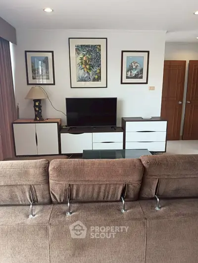 Stylish living room with modern decor, featuring a comfortable sofa, TV, and elegant wall art.
