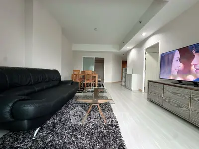 Spacious modern living room with sleek black sofa and stylish dining area
