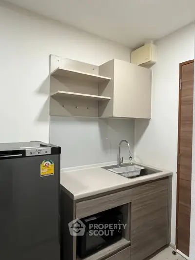Modern compact kitchen with sleek cabinetry and built-in appliances