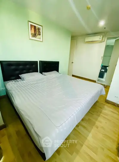 Spacious bedroom with modern decor and air conditioning in a stylish apartment.