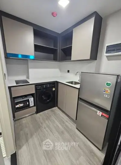 Modern compact kitchen with sleek appliances and efficient layout in urban apartment.