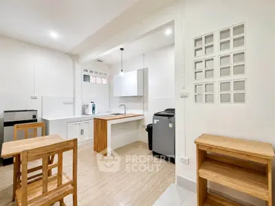 Modern kitchen with wooden furniture and sleek appliances in a bright, open layout.