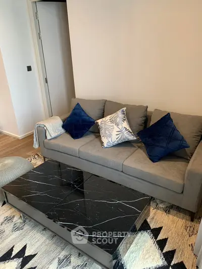 Stylish living room with modern gray sofa and elegant black marble coffee table