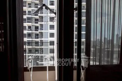 Modern apartment balcony with city view and drying racks, perfect for urban living.