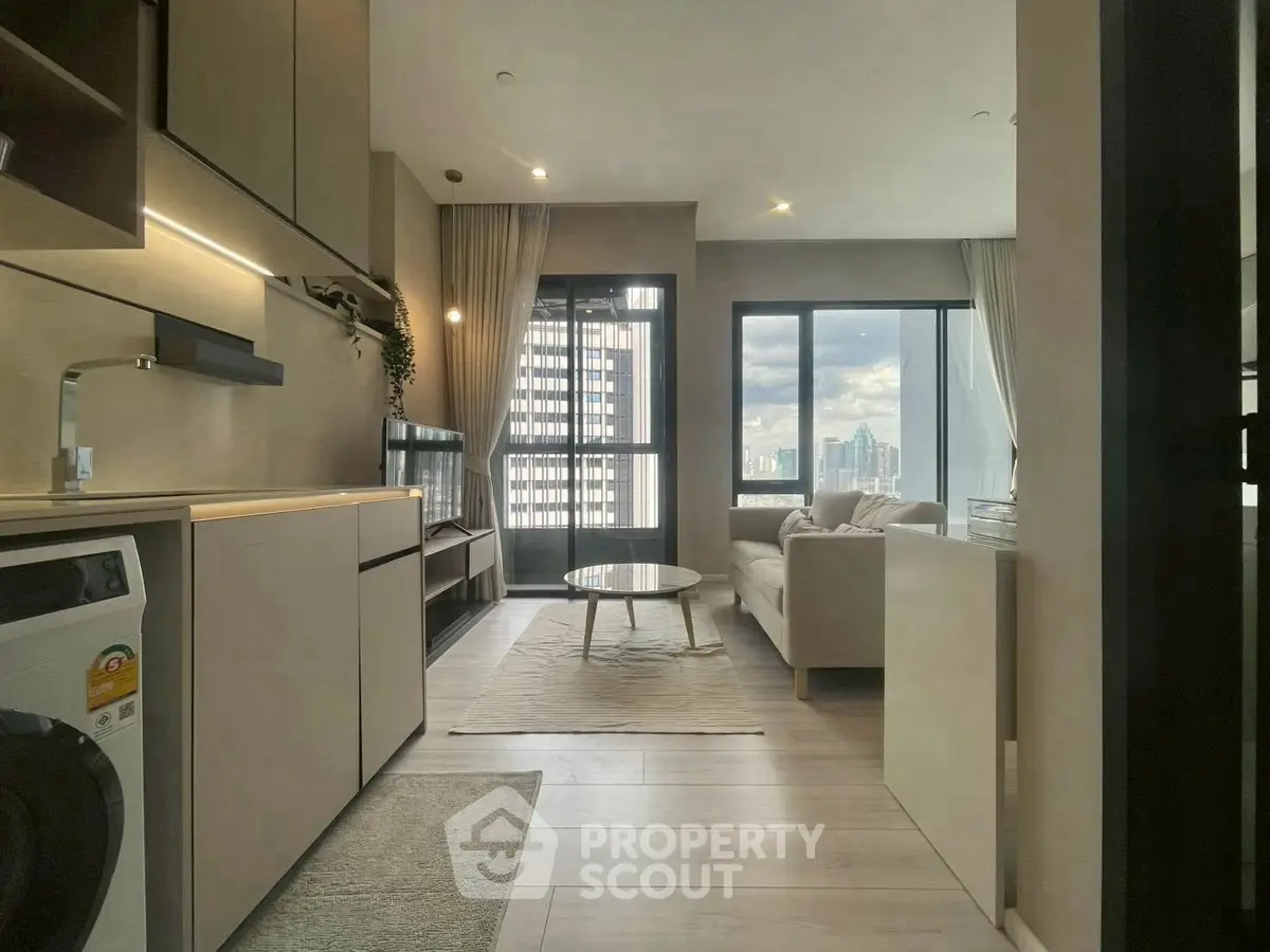 Modern living room with city view, featuring sleek furniture and integrated kitchen appliances.