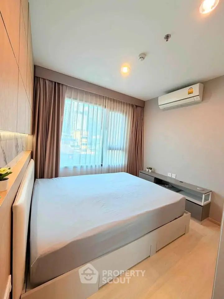 Modern bedroom with large window and air conditioning in stylish apartment