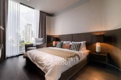 Luxurious bedroom with modern decor and city view, featuring elegant lighting and cozy bedding.
