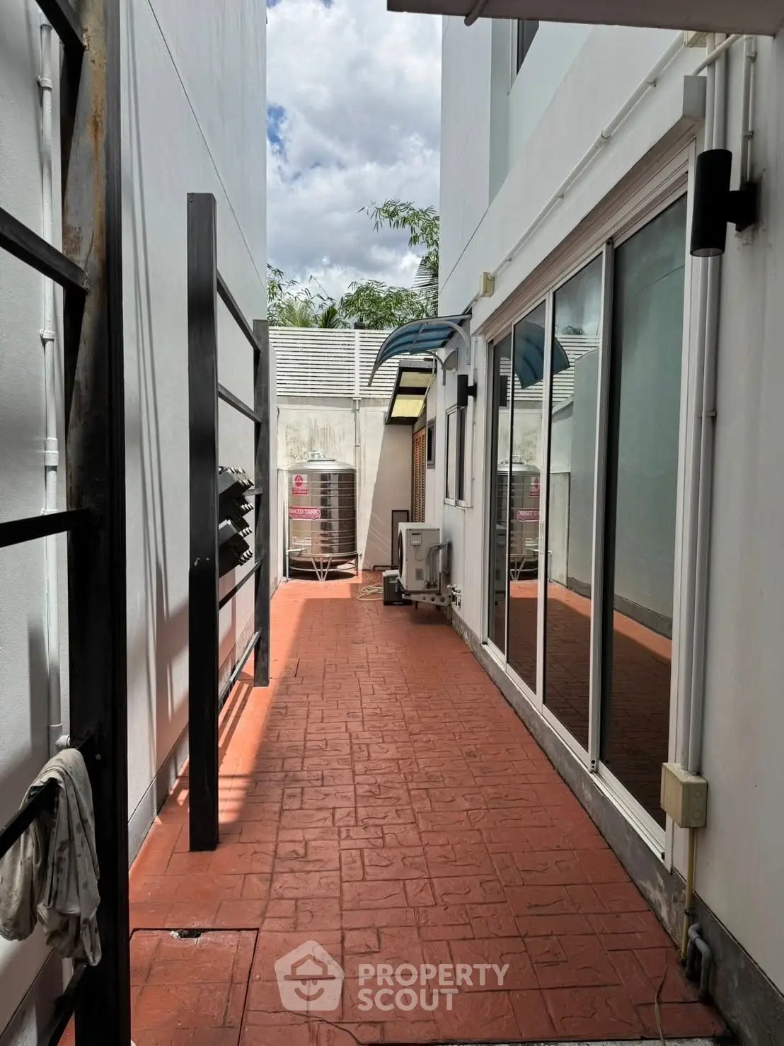 Spacious outdoor corridor with modern glass doors and red brick flooring
