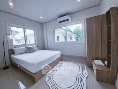 Modern bedroom with large windows, wooden furniture, and air conditioning in a bright, minimalist design.