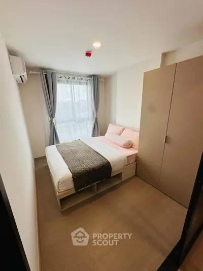Cozy modern bedroom with natural light and stylish decor in a contemporary apartment.