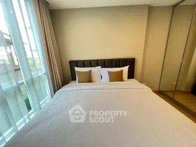 Spacious bedroom with large bed and mirrored wardrobe in modern apartment