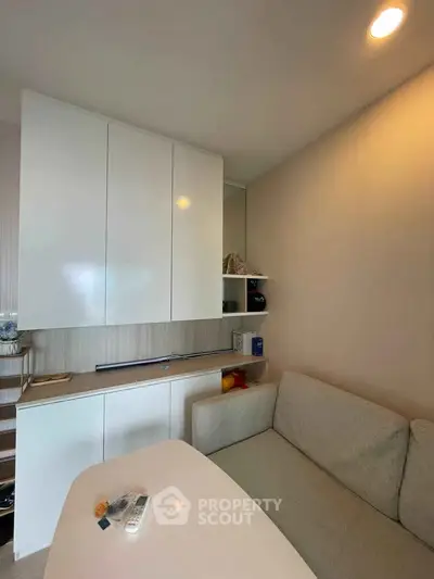 Cozy living room with modern furniture and built-in storage cabinets, perfect for urban living.