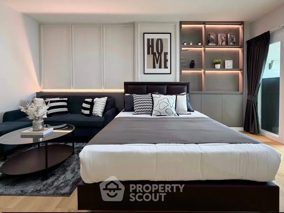 Modern bedroom with stylish decor and cozy seating area, perfect for relaxation and comfort.