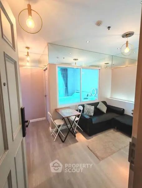 Cozy living room with modern lighting and comfortable seating, perfect for relaxation.