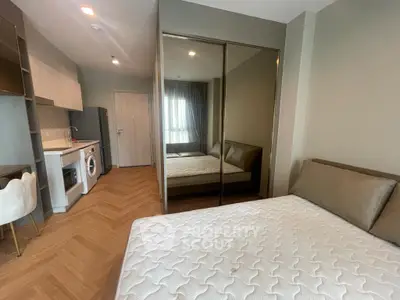 Modern studio apartment with stylish kitchen and cozy bedroom area