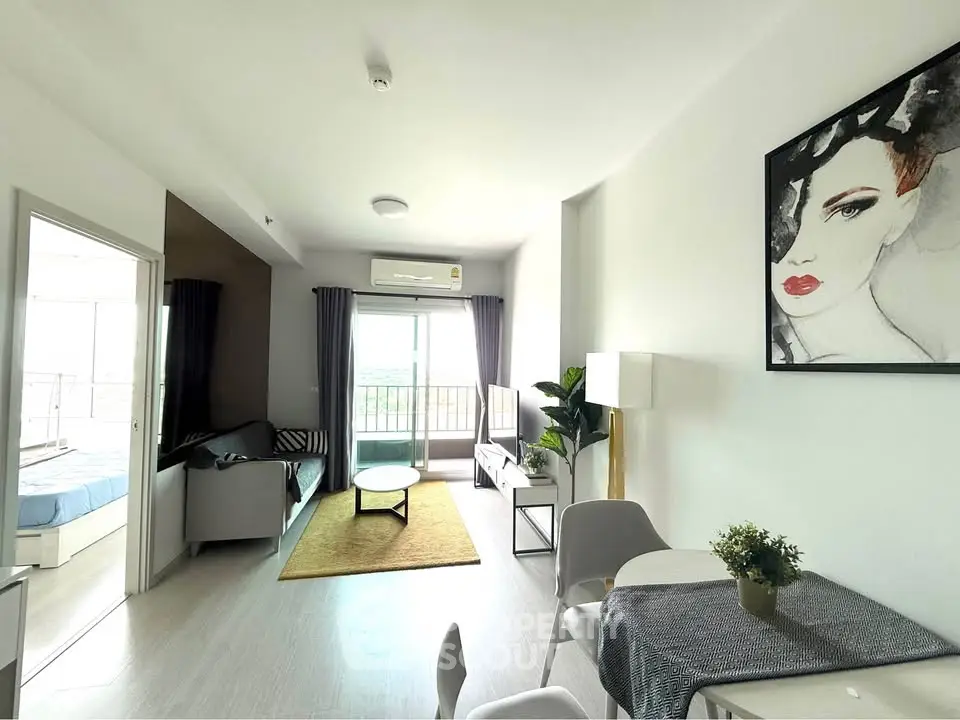 Modern living room with stylish decor and natural light, featuring a cozy seating area and contemporary artwork.