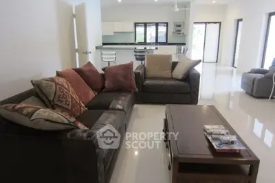 Spacious modern living room with plush sofas and open kitchen layout