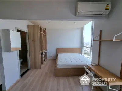 Modern bedroom with wooden flooring, large window, and minimalist furniture in a high-rise apartment.