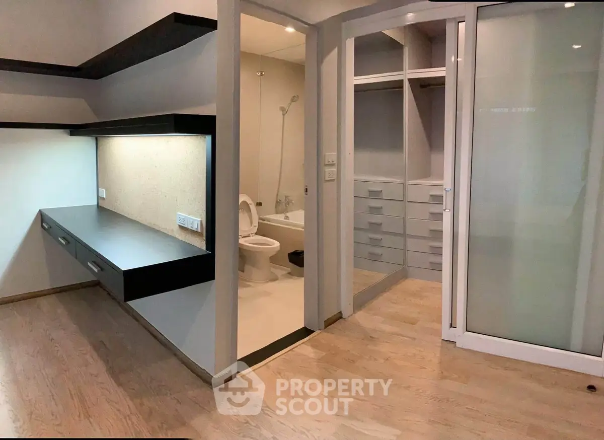 Modern interior with sleek bathroom and built-in storage, featuring elegant wood flooring and contemporary design.