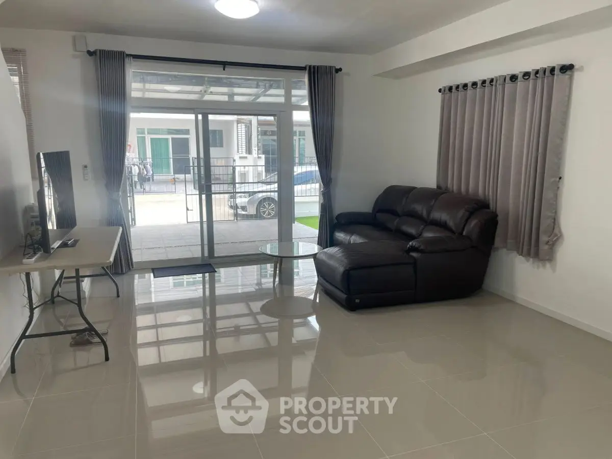 Spacious living room with modern furniture and large windows offering natural light.