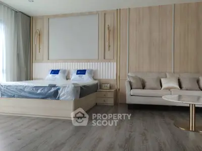 Spacious modern bedroom with elegant decor and cozy seating area