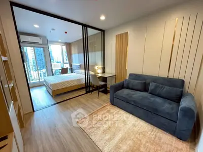 Modern studio apartment with cozy living area and stylish bedroom, featuring a large window with city view.