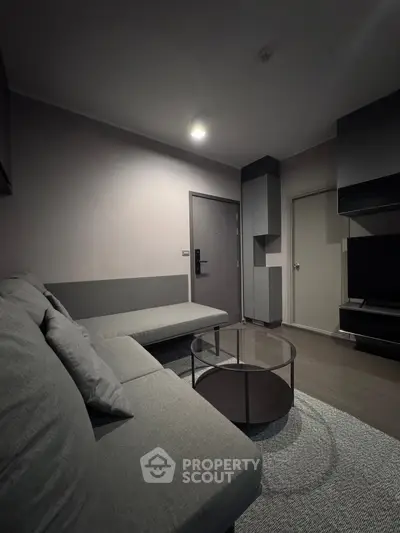 Modern living room with sleek gray sofa and glass coffee table, perfect for stylish urban living.