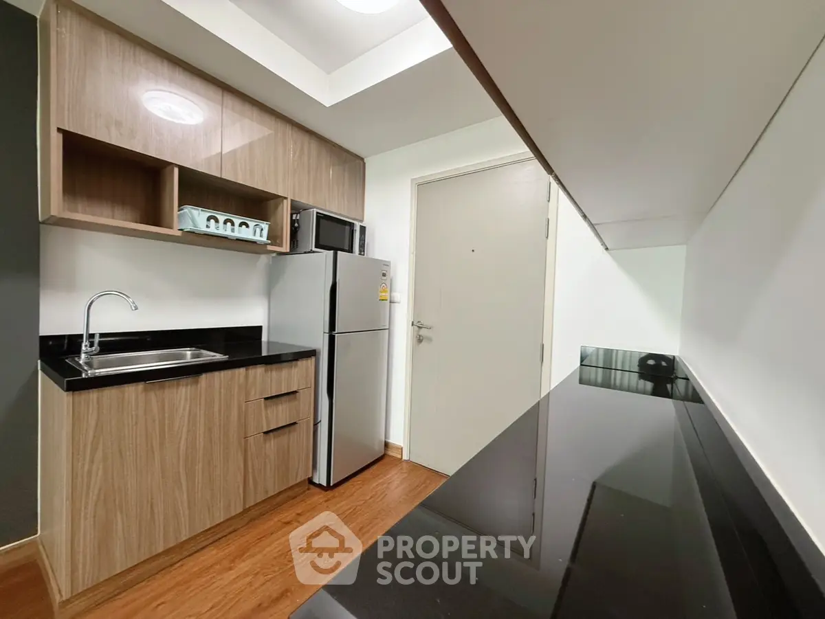 Modern kitchen with sleek cabinets and stainless steel appliances in a compact layout.