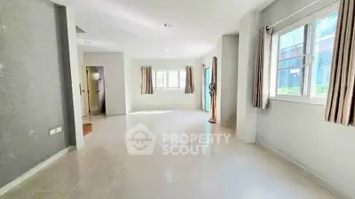 Spacious and bright living room with large windows and neutral decor