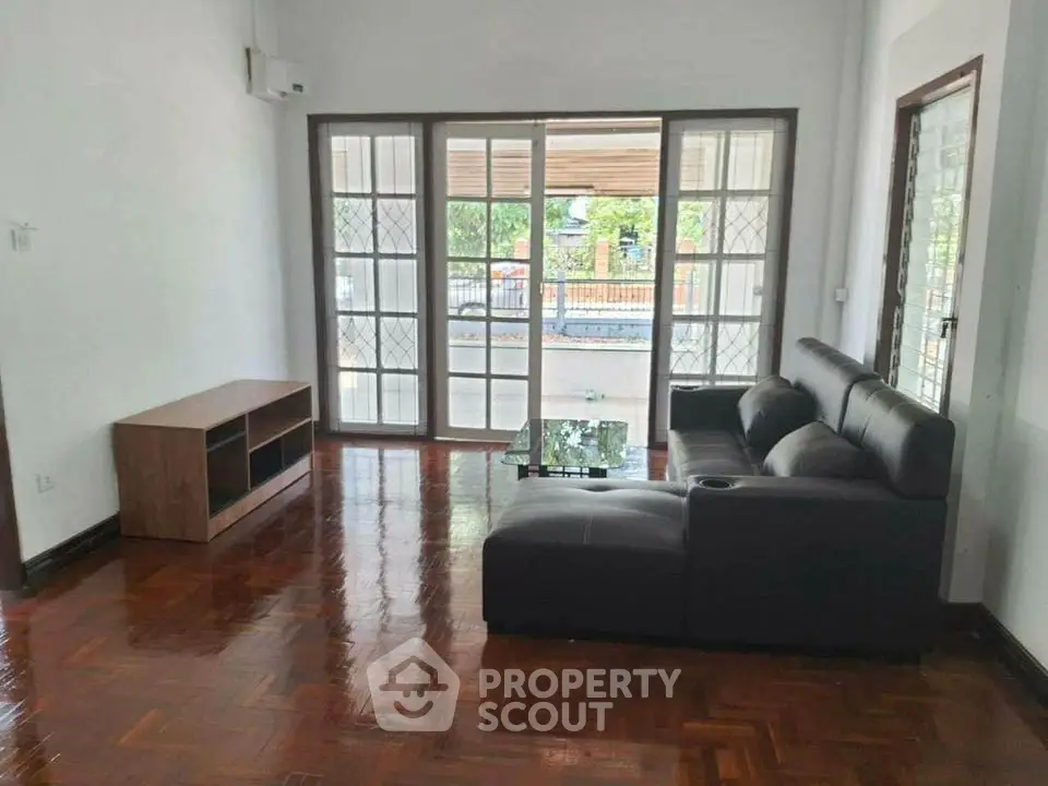 Spacious living room with elegant parquet flooring and modern furniture.