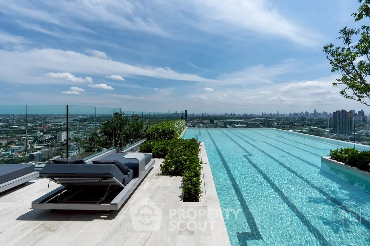 Luxurious rooftop pool with stunning city skyline view and modern lounge chairs.