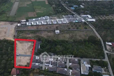 Aerial view of residential development with marked plot of land for sale.