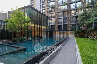 Modern apartment complex with sleek pool and lush greenery