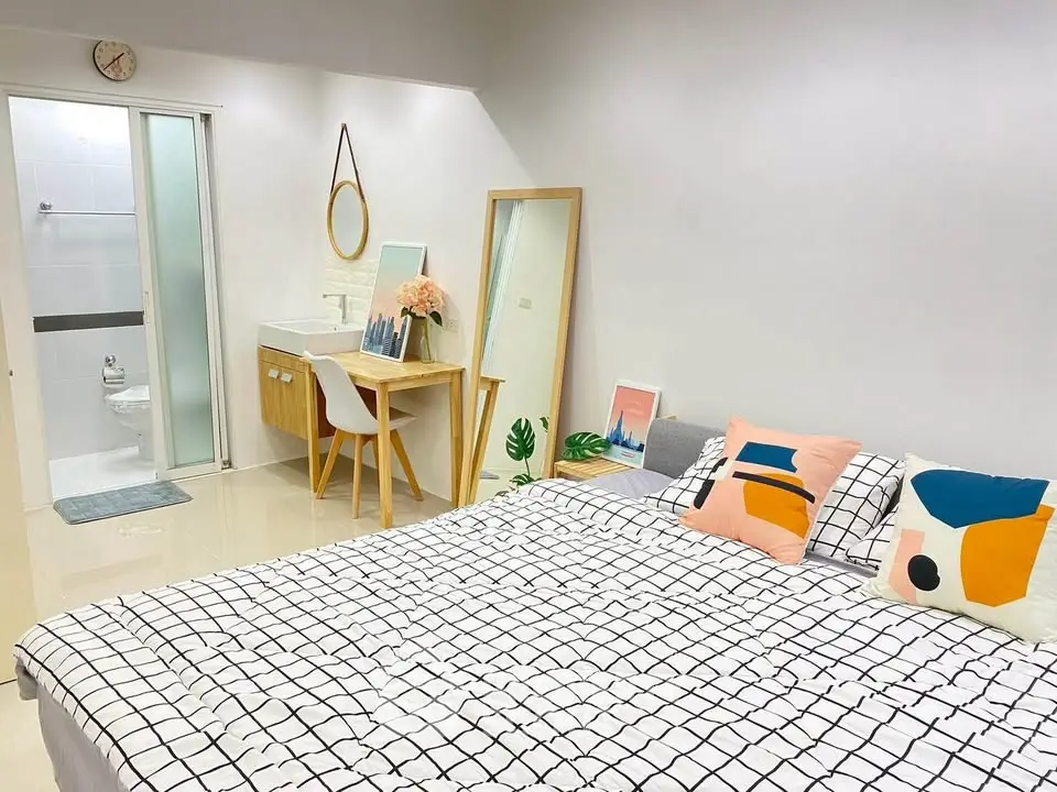 Modern bedroom with stylish decor and ensuite bathroom, featuring a cozy bed and elegant vanity area.