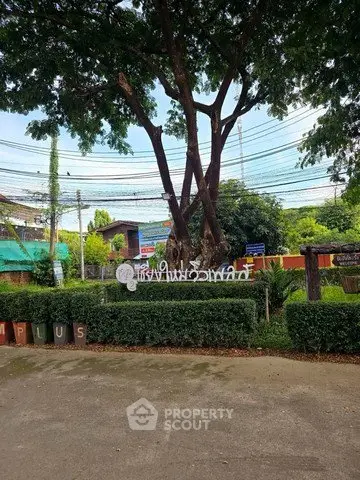 Charming garden entrance with lush greenery and welcoming signage
