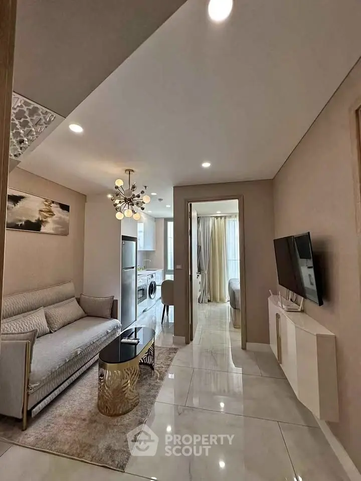 Modern living room with elegant decor, open layout, and natural light, featuring a stylish sofa and wall-mounted TV.