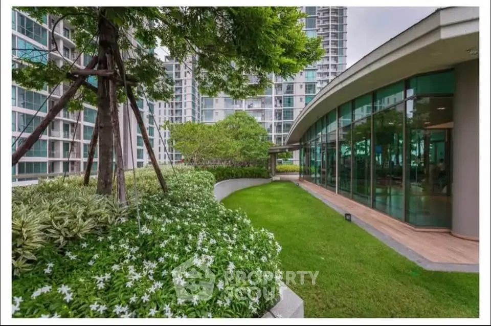 Luxurious garden area with modern building exterior and lush greenery in urban setting.