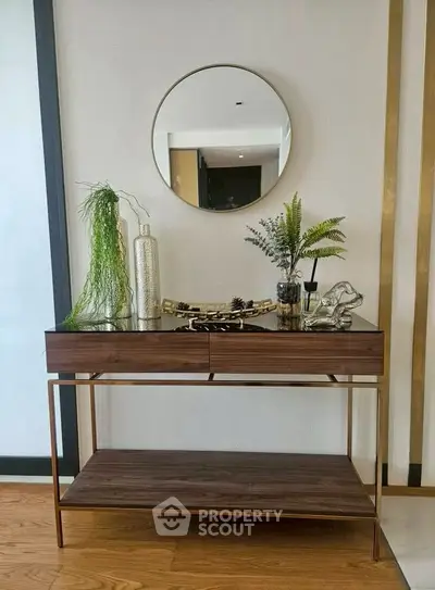 Stylish console table with decorative plants and mirror in modern living room.