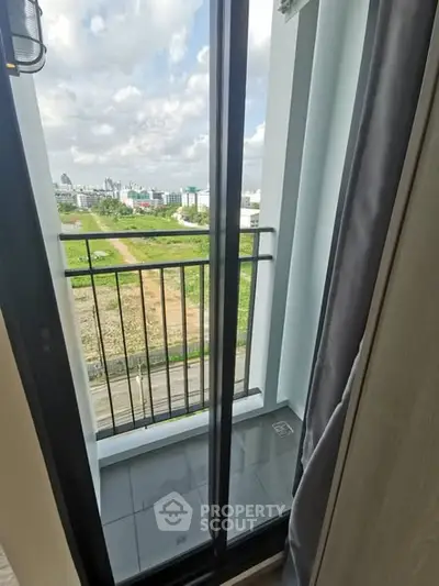 Charming balcony with scenic view of lush greenery and city skyline, perfect for relaxation.