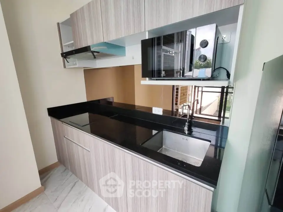 Modern kitchen with sleek cabinetry and built-in appliances in a stylish apartment.
